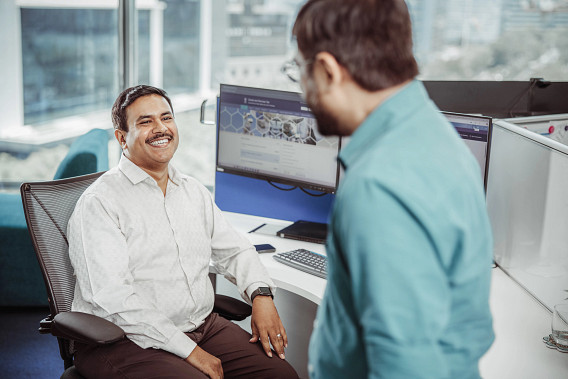 Two smiling colleagues having a conversation in the office